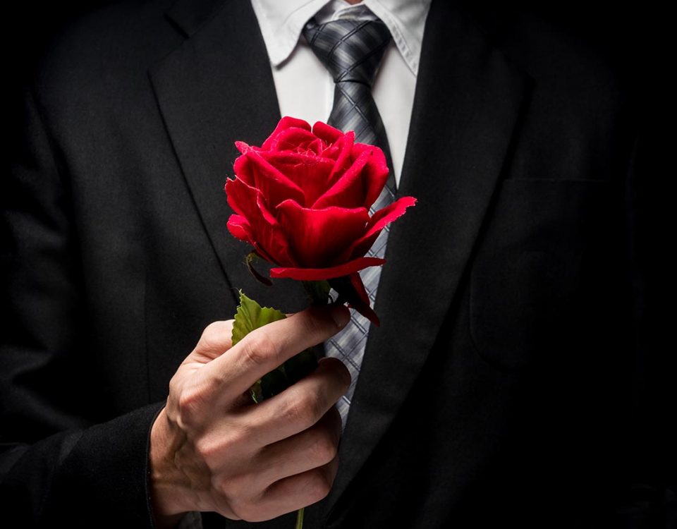 man in tux holding rose