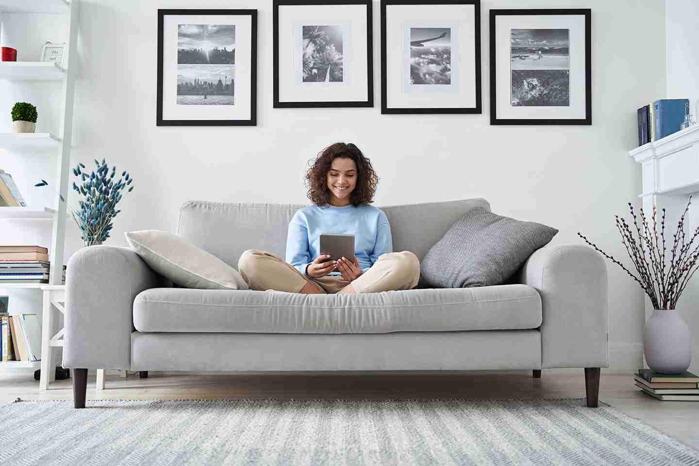 Woman relaxing on couch using telehealth on tablet
